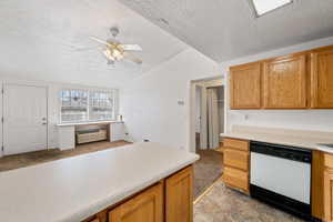 Kitchen with light carpet, a textured ceiling, white dishwasher, a wall unit AC, and ceiling fan