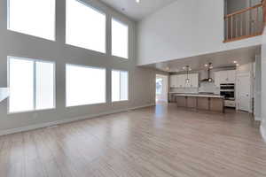 Unfurnished living room with sink and light hardwood / wood-style floors