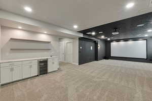 Cinema with light carpet, beverage cooler, and bar area