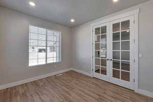 Empty room with french doors and light wood-type flooring