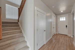 Foyer entrance with light wood-type flooring