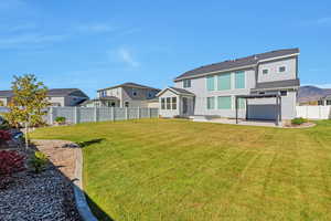 Rear view of house featuring a yard and a patio area