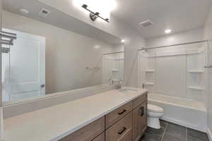 Full bathroom featuring tile patterned flooring, vanity, washtub / shower combination, and toilet