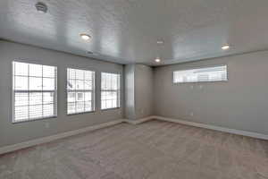 Carpeted empty room featuring a textured ceiling