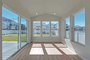 Unfurnished sunroom with a mountain view, vaulted ceiling, and plenty of natural light