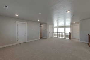 Carpeted empty room featuring a textured ceiling