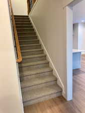 Stairway featuring hardwood / wood-style flooring