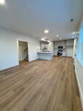 Unfurnished living room featuring hardwood / wood-style flooring and sink