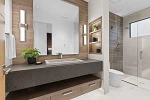 Bathroom featuring a stall shower, vanity, toilet, and tile patterned floors