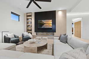 Living room with built in features, a ceiling fan, light wood-style flooring, a fireplace, and recessed lighting