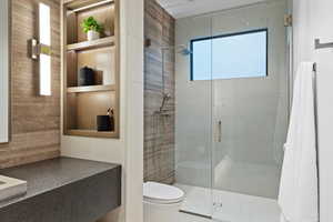 Bathroom with built in shelves, a stall shower, and toilet