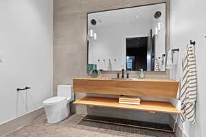 Bathroom with toilet, tile patterned flooring, and vanity