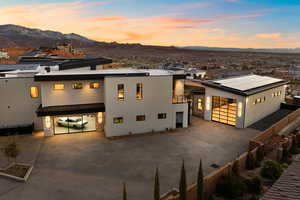 View of front of house with a standing seam roof, metal roof, a mountain view, fence, and driveway