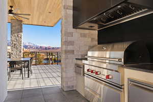 Exterior space with outdoor dining space, a mountain view, an outdoor kitchen, and ceiling fan