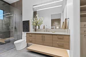 Bathroom featuring vanity, a shower stall, and toilet