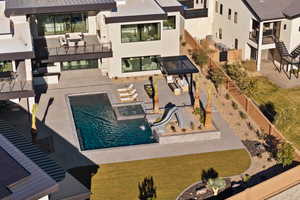 Outdoor pool featuring a patio area, a fenced backyard, a gazebo, and an in ground hot tub