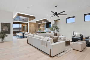 Living room with light wood-style flooring, baseboards, and ceiling fan