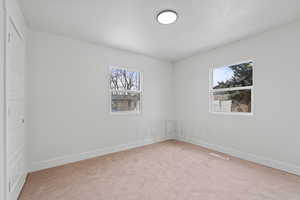 Carpeted empty room featuring a wealth of natural light