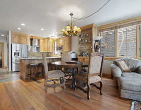 Dining area with a notable chandelier and light wood-type flooring