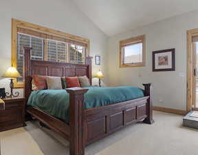 Carpeted bedroom featuring vaulted ceiling