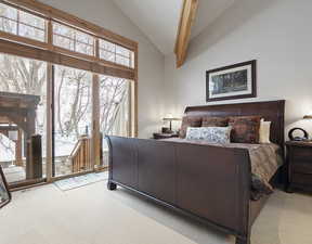 Carpeted bedroom featuring access to exterior and high vaulted ceiling