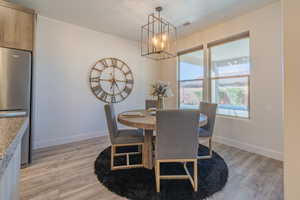 Dining area featuring an inviting chandelier and light hardwood / wood-style flooring