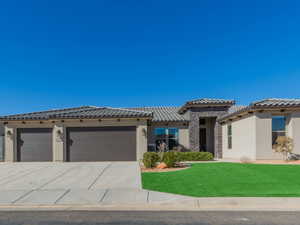 Mediterranean / spanish-style house with a garage and a front lawn