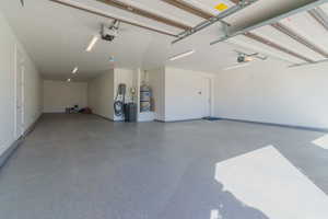 Garage with strapped water heater and a garage door opener