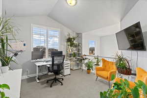 Carpeted office featuring vaulted ceiling