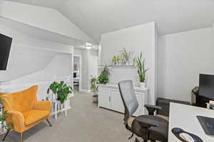 Office featuring lofted ceiling and light carpet