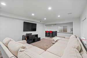 Carpeted living room featuring bar