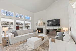 Living room featuring high vaulted ceiling and light wood-type flooring