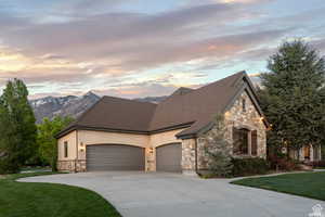 View of front of property with a garage, a mountain view, and a yard