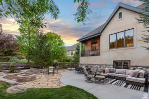 Patio terrace at dusk with an outdoor living space with a fire pit