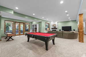 Rec room featuring french doors, pool table, and light carpet