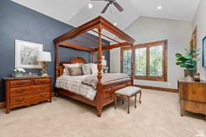 Bedroom with ceiling fan, vaulted ceiling, and light carpet