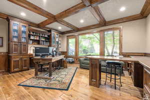 Office space featuring coffered ceiling, beam ceiling, ornamental molding, and light hardwood / wood-style floors