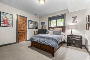 Carpeted bedroom featuring a textured ceiling