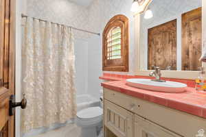 Full bathroom featuring shower / bathtub combination with curtain, vanity, and toilet