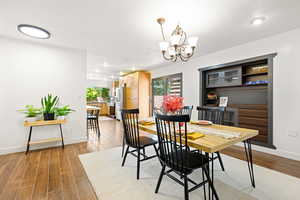 Dining space with wood-type flooring and a chandelier