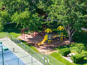 View of play area featuring a yard and tennis court