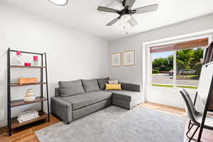 Living room with hardwood / wood-style flooring and ceiling fan