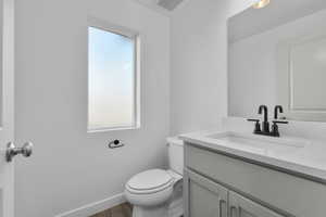 Bathroom featuring vanity, wood-type flooring, and toilet