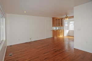 Unfurnished living room featuring dark hardwood / wood-style flooring and ceiling fan