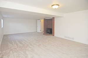 Unfurnished living room featuring a fireplace and light colored carpet