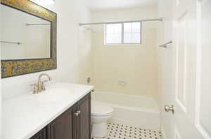 Full bathroom with vanity, tiled shower / bath, and toilet