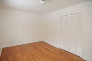 Unfurnished bedroom with hardwood / wood-style floors and a closet