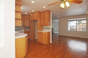 Kitchen featuring dark hardwood / wood-style floors, white range with gas stovetop, and ceiling fan