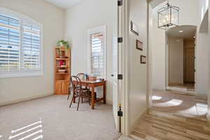 Office featuring light colored carpet and a chandelier