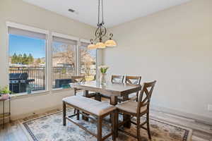 Dining space featuring hardwood / wood-style flooring, plenty of natural light, and an inviting chandelier